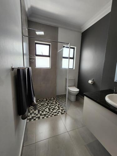 a bathroom with a shower and a toilet and a sink at La Chambre Manor House in Nelspruit