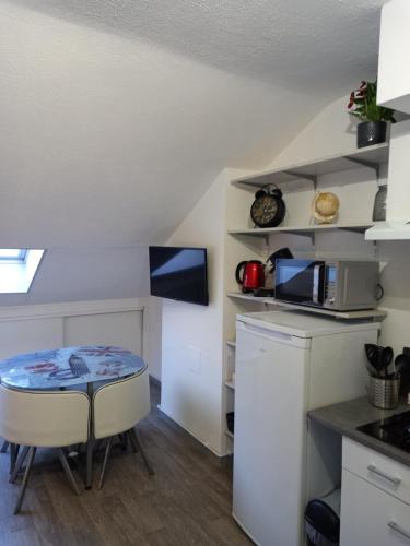 - une petite cuisine avec une petite table et un comptoir dans l'établissement Studio tout équipé, à Revigny-sur-Ornain