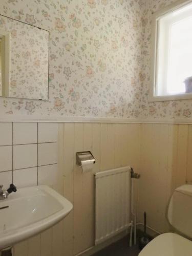 a bathroom with a sink and a toilet and a window at Klaraborg - Rum och kök i Borgvik in Borgvik