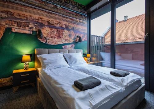 Un dormitorio con una cama grande y una pared verde en Apartamenty Plebańska-Rynek en Gliwice