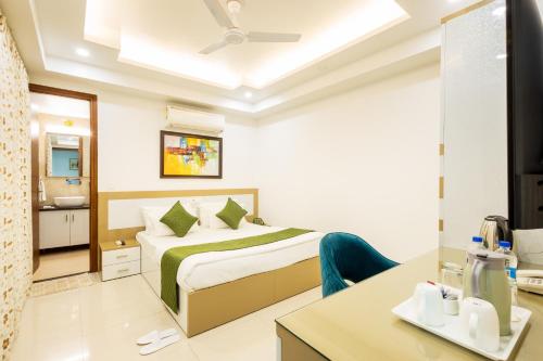 a hotel room with a bed and a desk at Hotel Krish - Near Medanta and Fortis Hospital Gurugram in Gurgaon