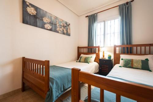 a bedroom with two beds and a window at Ático de lujo en primera línea 2 balcones con vistas al mar, Vera Playa in Vera