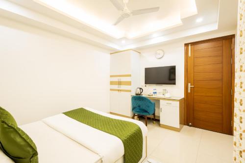 グルガオンにあるHotel Krish - Near Medanta and Fortis Hospital Gurugramのベッドとデスクが備わるホテルルームです。