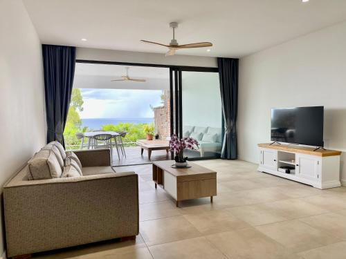 Una televisión o centro de entretenimiento en Appartement 2 chambres avec piscine, vue mer sur la baie