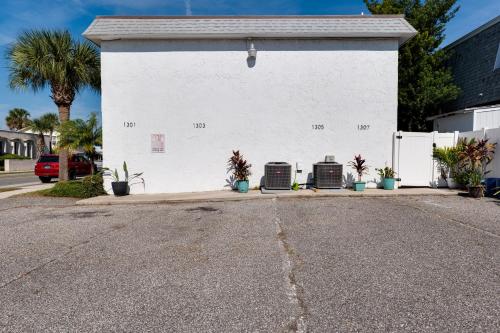 un edificio blanco con plantas a su lado en Be A Nomad l Charming 2 Bed Steps to Beach en Jacksonville Beach