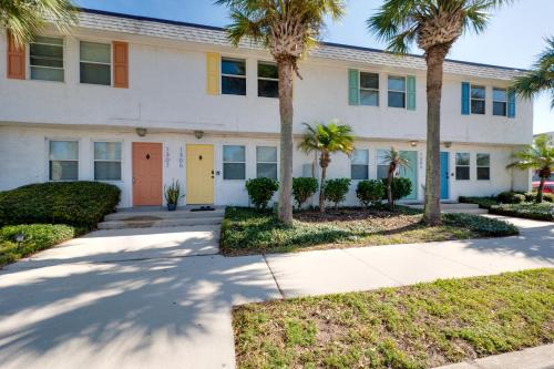 a building with palm trees in front of it at Be A Nomad l Charming 2 Bed Steps to Beach in Jacksonville Beach