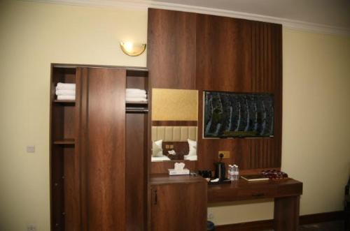 um quarto com uma secretária de madeira num quarto em Roaa Al Andalus Hotel فندق رؤى الاندلس em Medina