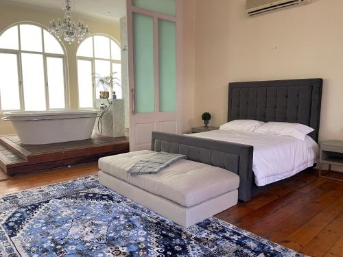 a bedroom with a large bed with a tub and a stool at Cosy city stay in Cape Town
