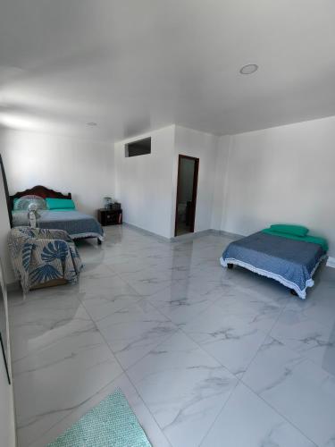 sala de estar con 2 camas y suelo de baldosa. en Cuarto en galápagos, en Puerto Baquerizo Moreno