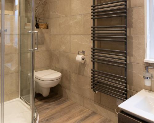 a bathroom with a toilet and a glass shower at West View in Milnthorpe