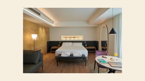 a bedroom with a bed and a couch and a table at Palazzo Sangiorgio in Catania