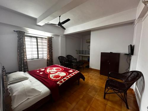 1 dormitorio con 1 cama, mesa y sillas en Dubai Hotel & Restaurant Kumarakom, en Kumarakom