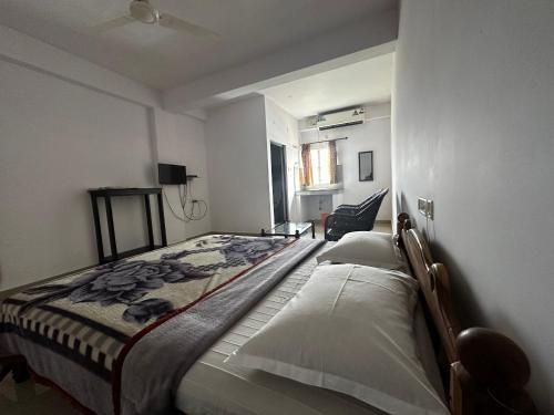 1 dormitorio con 1 cama y 1 silla en Dubai Hotel & Restaurant Kumarakom, en Kumarakom