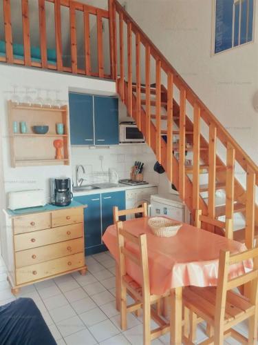 une cuisine avec une table et un escalier en bois dans l'établissement 4RB71 - APPARTEMENT F2 mezzanine avec vue mer, à Collioure