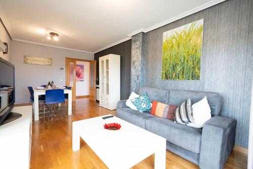 un soggiorno con un divano e un tavolo di Apartamentos GO - Arroyo Ático Regato A- 62 Salida 130 -Parking Gratuito ad Arroyo de la Encomienda