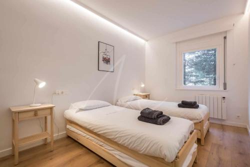 a bedroom with two beds and a window at Saboredo by SeaMount Rentals in Naut Aran