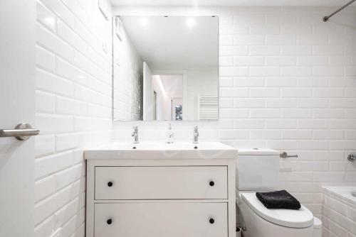 a white bathroom with a sink and a toilet at Saboredo by SeaMount Rentals in Naut Aran