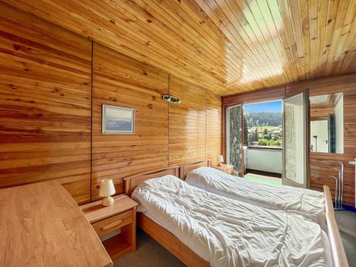 - une chambre avec 2 lits et un mur en bois dans l'établissement 3 Pièces 6/8 Pers centre Carroz (AA111), aux Carroz d'Arâches