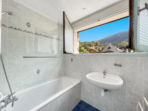 une salle de bain avec une baignoire, un lavabo et une fenêtre dans l'établissement 3 Pièces 6/8 Pers centre Carroz (AA111), aux Carroz d'Arâches