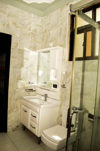 a bathroom with a sink and a toilet and a shower at Ateker Hotel in Lodwar