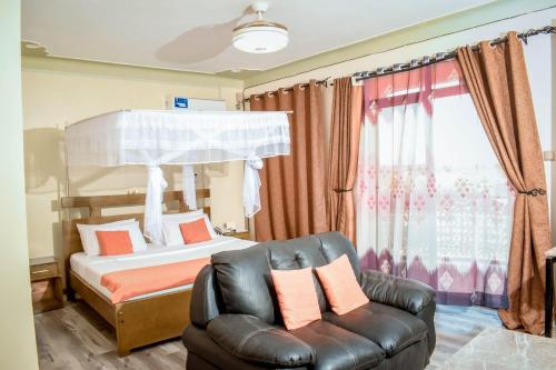 a bedroom with a bed and a leather chair at Ateker Hotel in Lodwar