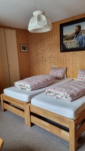 two beds in a room with a picture on the wall at Pension Hof zur Stilli in Davos