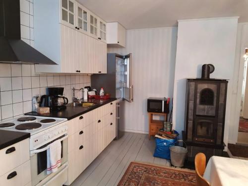 a kitchen with white cabinets and a stove top oven at Gamla Badhuset in Borgvik