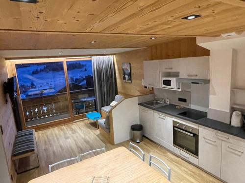 une cuisine avec une table et des chaises dans une pièce dans l'établissement Hotel Le Very, aux Saisies