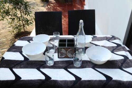 - une table en noir et blanc avec des bols et des bouteilles en verre dans l'établissement Marari Lois Beach Homes, à Mararikulam