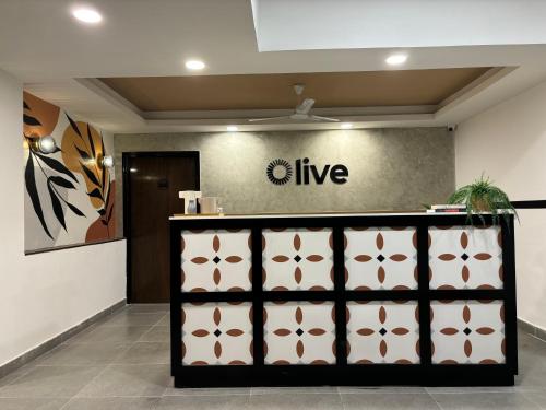 a store front with a sign that reads live at Olive Palace Road - by Embassy Group in Bangalore