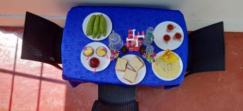 une table avec des assiettes de nourriture dessus dans l'établissement Marari Lois Beach Homes, à Mararikulam