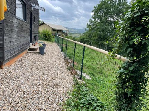 a fence on the side of a house at GITE CHALET BOIS in Bessuéjouls