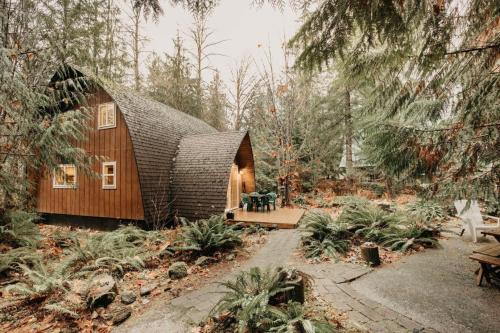 ein kleines Haus mit einem Strohdach im Wald in der Unterkunft 78MBR - Wood Stove - WiFi - Pets Ok - BBQ - Sleeps 6 home in Glacier