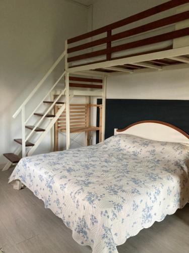 a bedroom with a bed and a bunk ladder at Barn House Pong Ta Long in Pong Talong