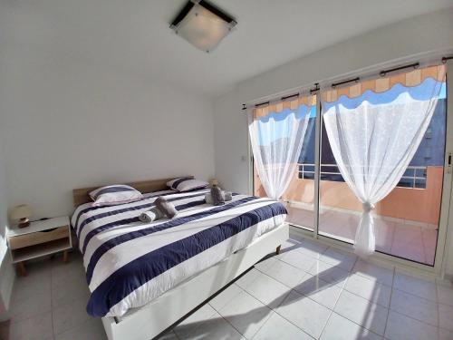 une chambre avec un lit et une grande fenêtre dans l'établissement Appartement T4 92M2 pour 6 pers à 400m de la plage, à Fréjus