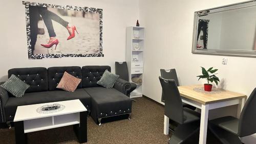a living room with a black couch and a table at Apartament "NADIA" na Starym Rynku in Zielona Góra