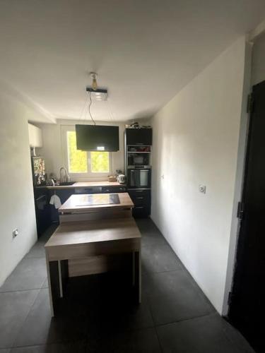 a kitchen with a table in the middle of a room at 2 chambres avec vue sur Lyon in La Mulatière