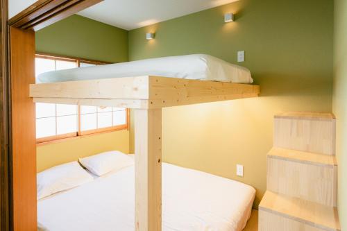 two bunk beds in a room with green walls at Beach side House SHELL kamakurahase in Kamakura