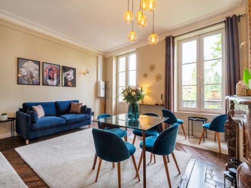 un salon avec un canapé bleu, une table et des chaises dans l'établissement Une Romance au bord de l’eau (en hyper-centre), à Metz