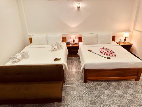 een hotelkamer met twee bedden met rozen erop bij Vida Loca Sunset Beach Resort in Phu Quoc