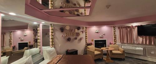 a room with pink walls and a table and chairs at Inn of the Dove - Romantic Luxury Suites with Jacuzzi & Seasonal Fireplace at Harrisburg-Hershey-Philadelphia, PA in Harrisburg