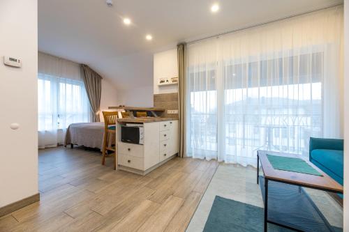 a room with a kitchen and a bedroom with a couch at Amber Drop apartments in Palanga