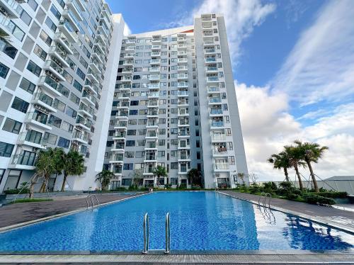 un gran edificio de apartamentos con piscina frente a él en Lu Homestay & Apartment, en Thôn Văn Dương