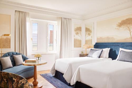 une chambre d'hôtel avec deux lits et un canapé dans l'établissement The Westin Palace, Madrid, à Madrid