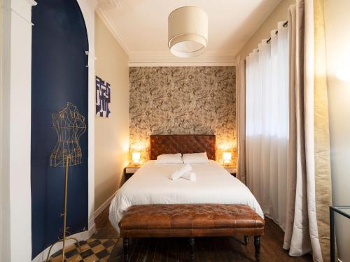 - une chambre avec un lit et un banc dans l'établissement Une Romance au bord de l’eau (en hyper-centre), à Metz