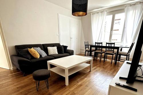 a living room with a couch and a table at Appartement 6 places, 3 chambres in La Mulatière