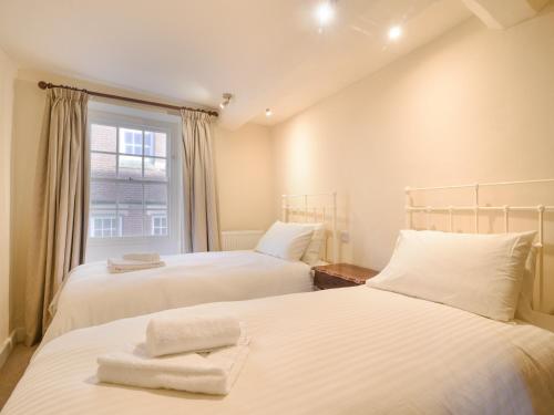 two beds in a room with a window at Malabar House in Lyme Regis