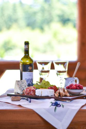 a table with a plate of food and a bottle of wine at Cabana Bavareză in Porumbacu de Sus