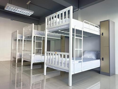 Zimmer mit 3 Etagenbetten in einem Zimmer in der Unterkunft PJ Hostel in Pak Chong