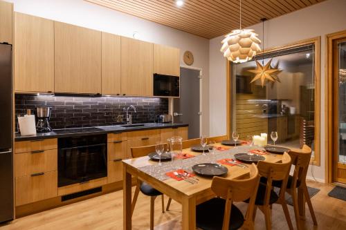a kitchen with a table with chairs and a dining room at Villa Blueberry in Rovaniemi